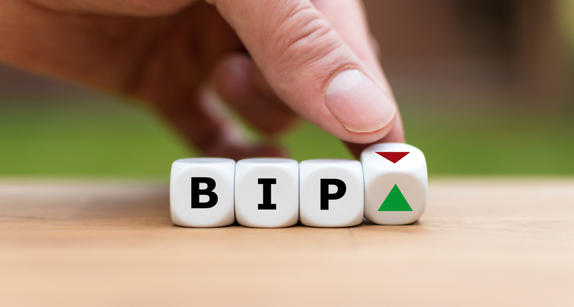 Hand würfelt und ändert die Richtung eines Pfeils, der symbolisiert, dass das BIP ("BIP") eines Landes den Trend ändert und nach oben statt nach unten geht (oder umgekehrt).