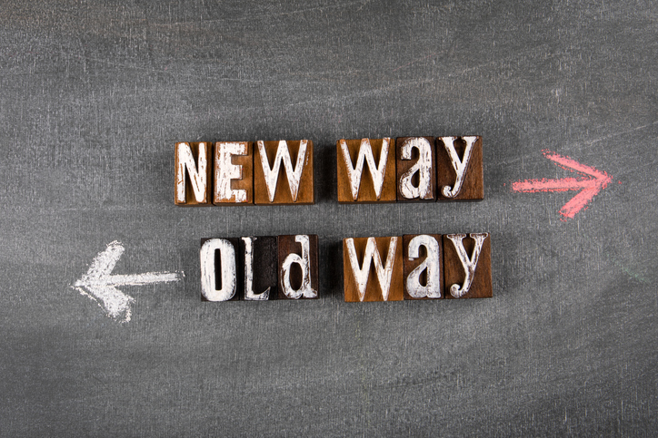 Tafel mit zwei auseinandergehenden Pfeilen und Buchstabentafeln "New Way" "Old Way"