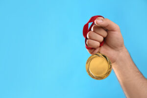 Hand hält Medaille © Liudmila Chernetska iStock Getty Images Plus