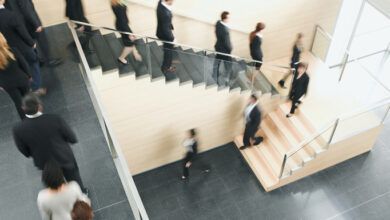 Angestellte gehen nacheinander eine Treppe hinunter