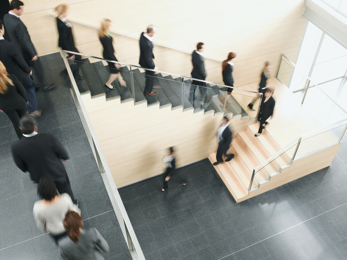Angestellte gehen nacheinander eine Treppe hinunter