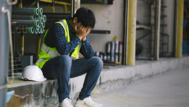 Entlassener Fabriksarbeiter legt den Kopf in die Hände